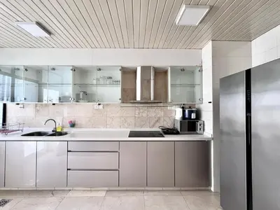 a kitchen with white cabinets and a stainless steel refrigerator at Fahrenheit 88 Kuala Lumpur in Kuala Lumpur
