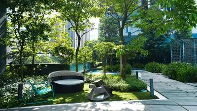 a garden with a bench and a chair and trees at Star Premier KLCC Suite 3-4pax by LavishHome in Kuala Lumpur