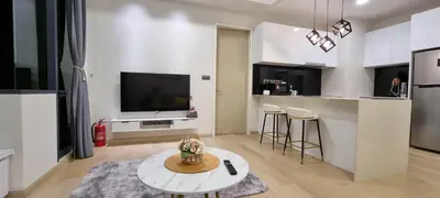 a living room with a table and a kitchen with a tv at Star Premier KLCC Suite 3-4pax by LavishHome in Kuala Lumpur