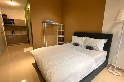 a bedroom with a large bed with white sheets and pillows at KLCC view cozy studio apartment Trion C243A KL in Kuala Lumpur
