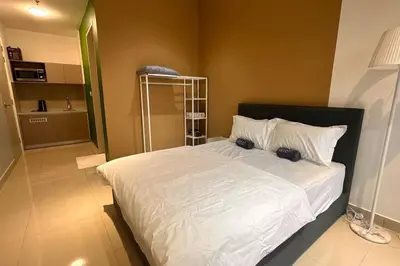 a bedroom with a large white bed with two cameras on it at KLCC view cozy studio apartment Trion C243A KL in Kuala Lumpur