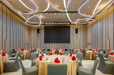 a conference room with tables and chairs and a projection screen at Holiday Inn Kuala Lumpur Bangsar by IHG in Kuala Lumpur