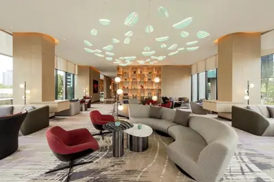 a hotel lobby with couches and red chairs at Holiday Inn Kuala Lumpur Bangsar by IHG in Kuala Lumpur