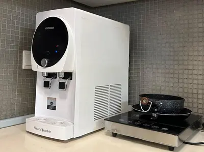 a microwave oven in a kitchen next to a table at Bintang Fairlane Residence, Cozy Fam Suite with Bathtub - 2B2R in Kuala Lumpur