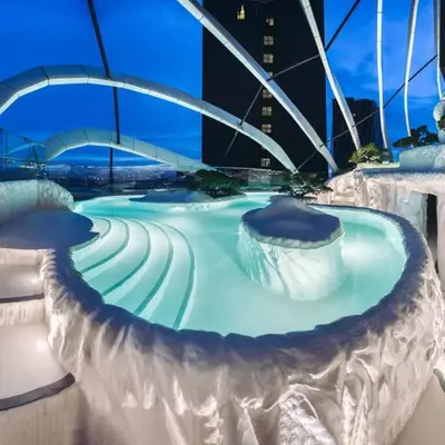 a large swimming pool in a city at night at Arte Mont Kiara in Kuala Lumpur