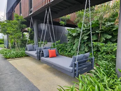 a swing with two pillows on it in a garden at 2R2B Chan Sow Lin Trion 2 - 6 pax in Kuala Lumpur