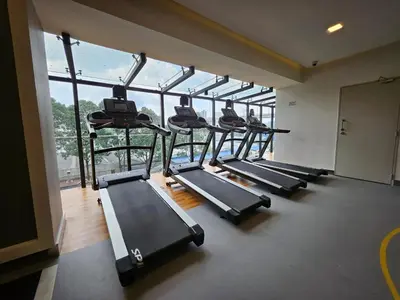 a row of treadmills in a gym with large windows at 2R2B Chan Sow Lin Trion 2 - 6 pax in Kuala Lumpur