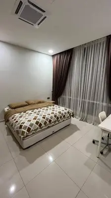 a bedroom with a bed and a window with curtains at City Centre KLCC in Kuala Lumpur