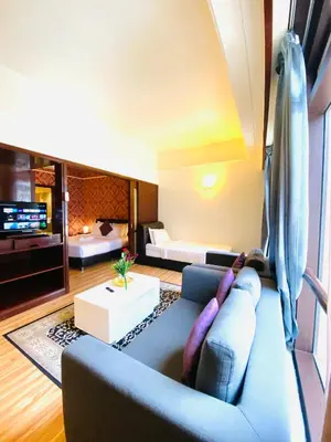 a living room with a blue couch and a bedroom at Unique Suite Times Square at Bukit Bintang Kuala Lumpur in Kuala Lumpur