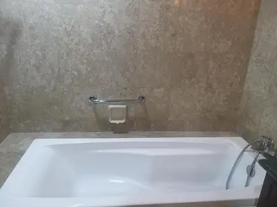 a white bath tub in a bathroom with a tile wall at Unique Suite Times Square at Bukit Bintang Kuala Lumpur in Kuala Lumpur