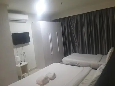 a hotel room with two beds and a television at Times Square Super Suites at Bukit Bintang KL in Kuala Lumpur
