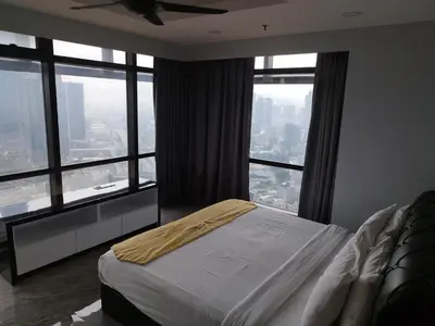 a bedroom with a bed and large windows at Times Square Super Suites at Bukit Bintang KL in Kuala Lumpur