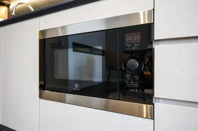 a microwave oven with a clock on it at Scarletz Suites KLCC by GB in Kuala Lumpur