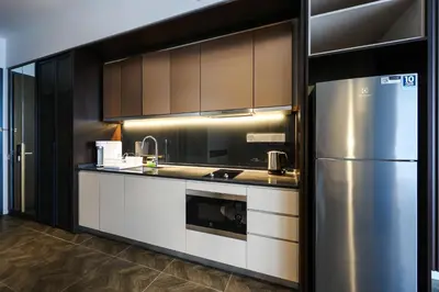 a kitchen with a stainless steel refrigerator and cabinets at Scarletz Suites KLCC by GB in Kuala Lumpur