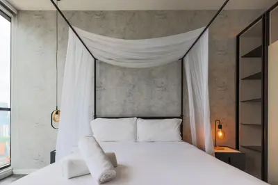 a bedroom with a white bed with a canopy at Scarletz Suites KLCC by GB in Kuala Lumpur
