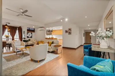 a living room with blue chairs and a dining room at Fahrenheit 88 Pavillion Bukit Bintang 3 bedroom in Kuala Lumpur
