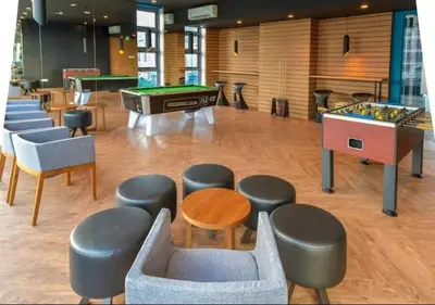 a room with tables and chairs and a pool table at robertson by katie suites in Kuala Lumpur