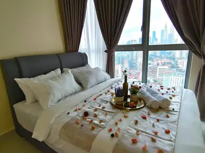a large bed with flowers on it with a window at Regalia Residence by Luvit Stay in Kuala Lumpur