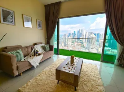 a living room with a couch and a large window at Regalia Residence by Luvit Stay in Kuala Lumpur