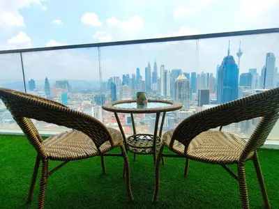 two chairs and a table with a view of a city at Regalia Residence by Luvit Stay in Kuala Lumpur