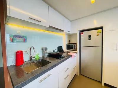 a white kitchen with a sink and a refrigerator at EST Bangsar KL Sentral by DeUrban in Kuala Lumpur
