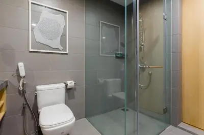 a bathroom with a toilet and a glass shower at 188 Premium Suites by Plush in Kuala Lumpur