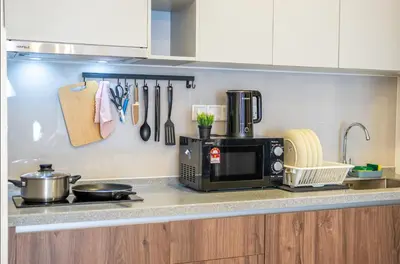 a kitchen counter with a stove and a microwave at M-Vertica Sunway Velocity Cheras by Luvit Stay in Kuala Lumpur