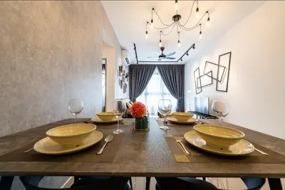 a dining room with a table with plates and wine glasses at M-Vertica Sunway Velocity Cheras by Luvit Stay in Kuala Lumpur