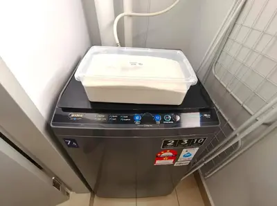 a washing machine sitting in a corner of a room at M-Vertica Sunway Velocity Cheras by Luvit Stay in Kuala Lumpur