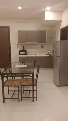 a kitchen with a table and chairs and a refrigerator at Regalia Suite 12-13 in Kuala Lumpur
