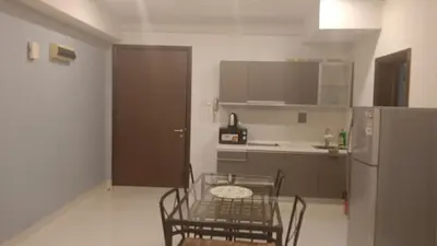 a kitchen with a table and chairs and a refrigerator at Regalia Suite 12-13 in Kuala Lumpur
