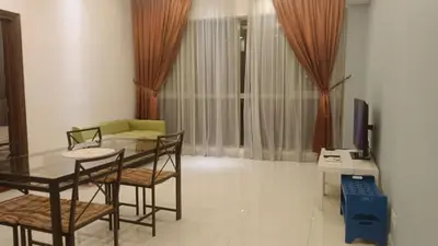 a living room with a table and chairs and a television at Regalia Suite 12-13 in Kuala Lumpur
