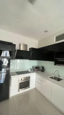 a kitchen with white cabinets and a black refrigerator at City Centre KLCC in Kuala Lumpur