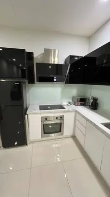 a kitchen with white cabinets and black appliances at City Centre KLCC in Kuala Lumpur
