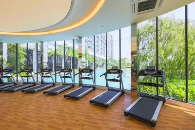 a row of treadmills in a gym with windows at Trion KL by Dreamcloud Sdn Bhd in Kuala Lumpur