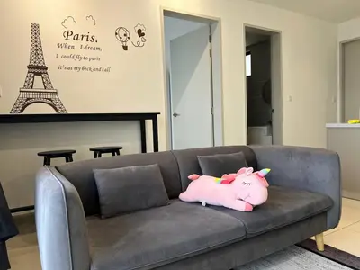 a pink pig pillow on a couch with the eiffel tower at Trion KL by Dreamcloud Sdn Bhd in Kuala Lumpur