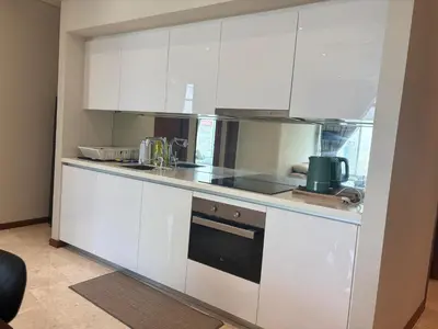 a kitchen with white cabinets and a stove at SkySuites Luxury Suite By CalmSojourn in Kuala Lumpur