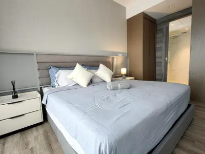 a bedroom with a large white bed with a night stand at TRX Agile Bukit Bintang KLCC View 8pax Family Suites in Kuala Lumpur