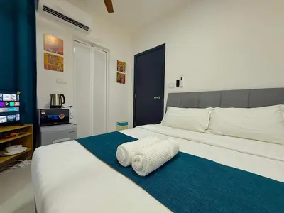 a bedroom with a large white bed and a television at Neu Suites Junior Suite By Serenity Homes Next to Gleneagles & LRT in Kuala Lumpur