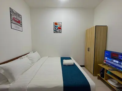 a bedroom with a bed and a flat screen tv at Neu Suites Junior Suite By Serenity Homes Next to Gleneagles & LRT in Kuala Lumpur