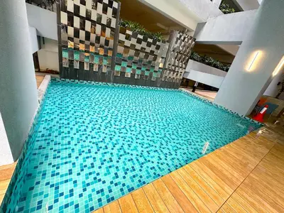 a large swimming pool with blue tiles in a building at Neu Suites Junior Suite By Serenity Homes Next to Gleneagles & LRT in Kuala Lumpur