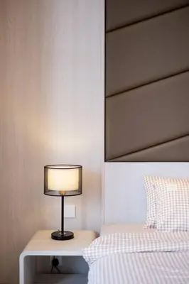 a lamp sitting on a table next to a bed at Societe Studio Sri Hartamas By Feel Home in Kuala Lumpur