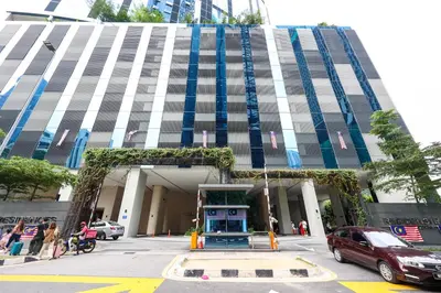 a tall building with people walking in front of it at Eaton Residence KLCC by GB in Kuala Lumpur