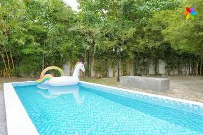 a white swan in a swimming pool with a rainbow at 30P White House Retreat - Pool & Event Hall in Kuala Lumpur