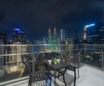 a table and chairs on a balcony with a city skyline at Moonway Luxury Suites At TM KLCC City Center in Kuala Lumpur