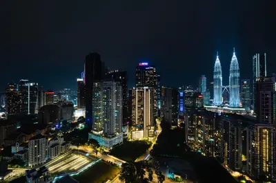 a city skyline at night with lit up buildings at Moonway Luxury Suites At TM KLCC City Center in Kuala Lumpur