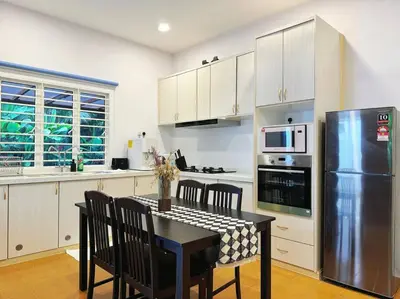 a kitchen with a table with chairs and a refrigerator at The Heritage Mid Valley l KL Sentral l 8 Pax in Kuala Lumpur