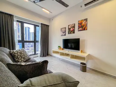 a living room with a couch and a television at Agile Bukit Bintang FaceHome, TRX, Pavilion, KL in Kuala Lumpur
