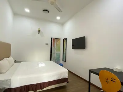 a bedroom with a bed and a table and a tv at Miharja Studio Private room with Auto gate Parking in Kuala Lumpur