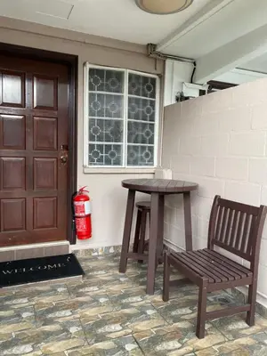 a wooden table and a bench next to a door at Miharja Studio Private room with Auto gate Parking in Kuala Lumpur